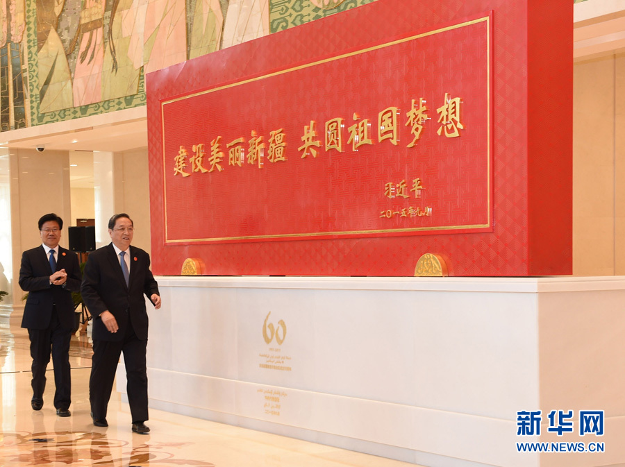 這是俞正聲和中共中央政治局委員、新疆維吾爾自治區(qū)黨委書記張春賢一同為習近平總書記題詞賀匾揭幕。新華社記者 高潔 攝 