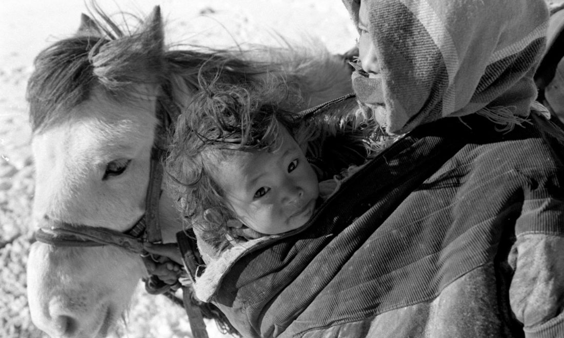 1990年3月，西藏當(dāng)雄縣納木湖鄉(xiāng)三村女牧民斯卓不畏嚴(yán)寒，懷抱幼子，準(zhǔn)備到遠(yuǎn)處放牧。新華社記者覺(jué)果攝