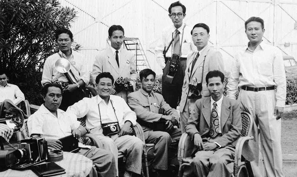 新華社記者錢嗣杰（站立者右二）在采訪會議開幕式后和外國記者在會場外休息。